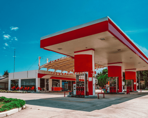 A modern gas station with multiple fuel pumps and a convenience store, illustrating a commercial property type often subject to complex valuation issues in California eminent domain cases, including business operations, equipment, and land value.