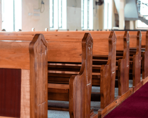 Empty church sanctuary with wooden pews, illustrating the unique value of church property and eminent domain considerations beyond market value and income potential.